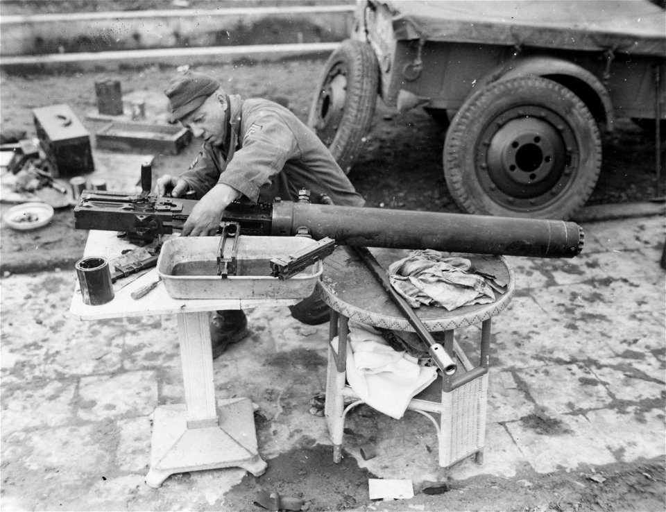 SC 364538 - T/4 Frank Usiak of 1119 Berkshire Ave., Pittsburg, Pa., 3rd U.S. Army, gives his .50 caliber water-cooled machine gun an overhaul near Echternach, Luxembourg.