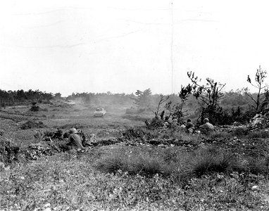 SC 270799 - Soldiers of the 32nd Regt., Co. F, 7th Division and tanks lay down grazing fire with .30 cal. machine guns to reveal enemy as target for the 75mm guns on the tanks. 15 June, 1945. photo