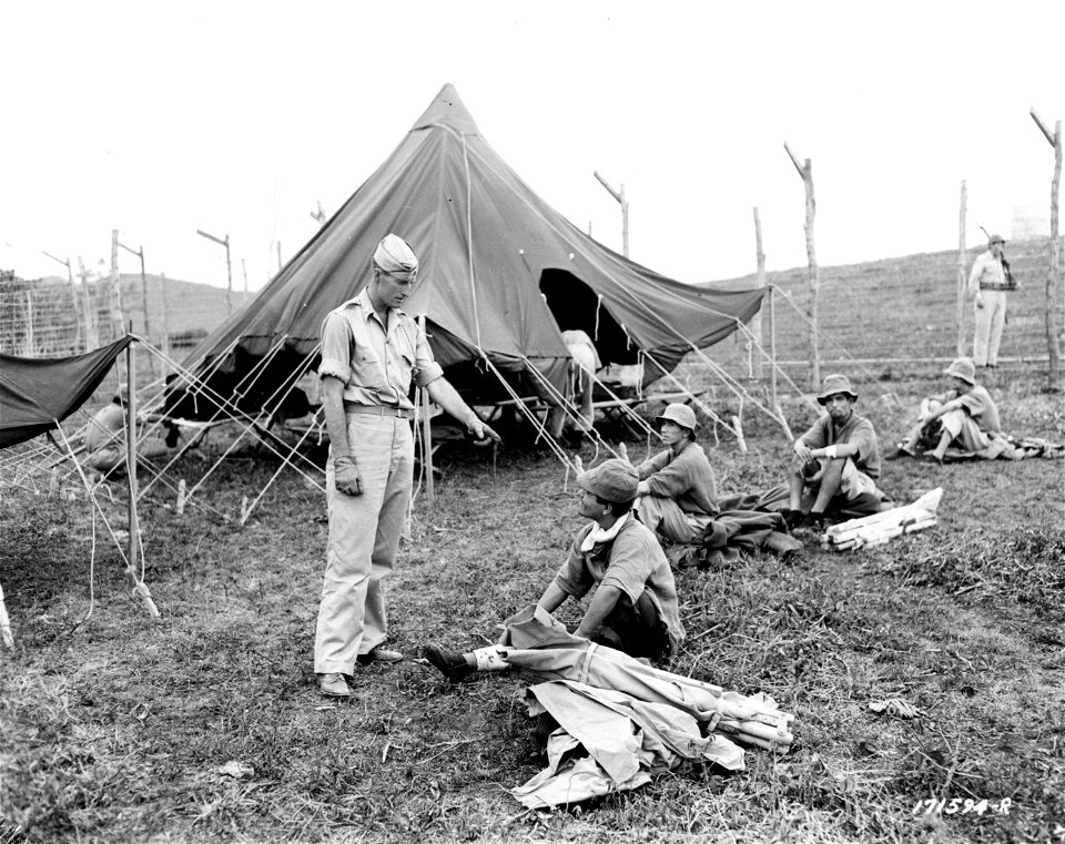SC 171594-R - First Island Command, New Caledonia. 2nd Lt. Russell F. Kiloran, 244th Coast Artillery, directs moving of Japanese prisoners into their new quarters at a recently completed prison camp.