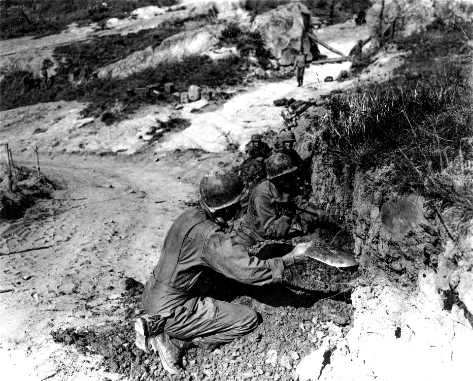 SC 337139 - Infantrymen of the 1st Armored Division dig foxholes in the embankment along the roadside, affording them complete protection from airbursts or mortar fire, on the top of Mt. Valbura.