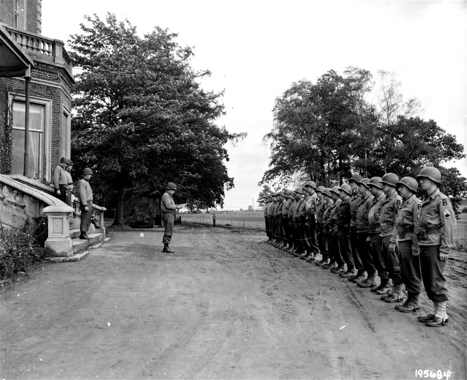 SC 195684 - Officers and men of Yank units hear citations read at First Army headquarters in France prior to receiving Bronze Stars from Major General Courtney Hodges, Commanding General, First United States Army. 20 October, 1944.