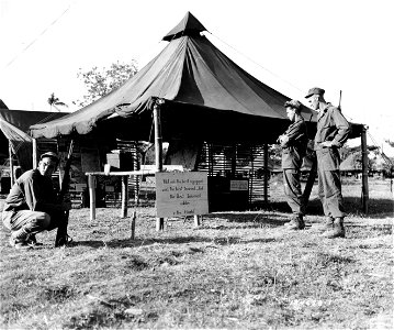 SC 184655-1 - Men of the 32nd Division are standing outside the Information and Education Tent at the Headquarters of the 32nd Division. Taytay, Luzon, P.I. 11 March, 1945. photo