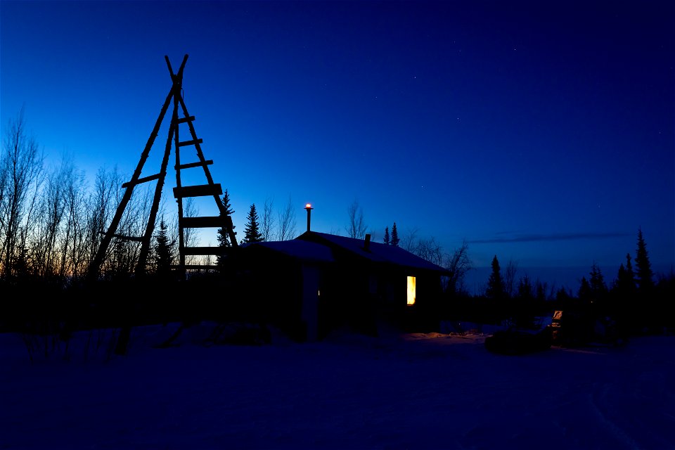 A snowmachine and sled outside the Paniqsigvik shelter cabin.