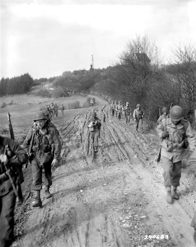 SC 270683 - Infantrymen of the 5th Division, U.S. Third Army, march on Wintersbach, Germany, to clear out the few remaining Nazis cut off from their main units. 18 March, 1945.