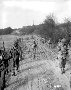 SC 270683 - Infantrymen of the 5th Division, U.S. Third Army, march on Wintersbach, Germany, to clear out the few remaining Nazis cut off from their main units. 18 March, 1945.