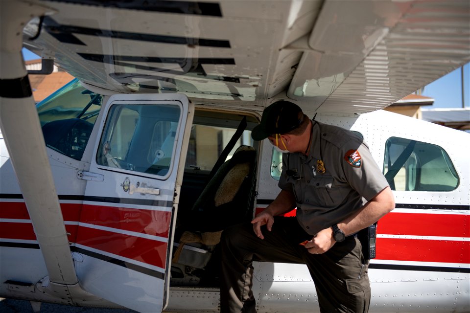 Park ranger next to NPS patrol plane