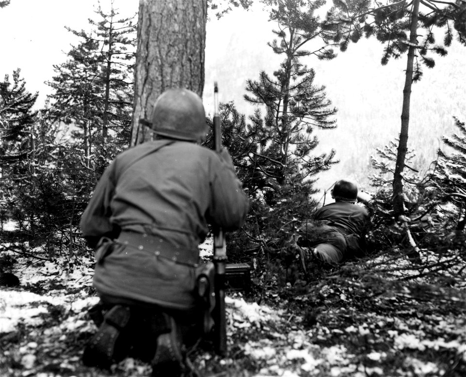 SC 337382 - Here, an enemy machine gun opens up from the far side of the valley. Both men watch intently, trying to spot it. 1 May, 1945.