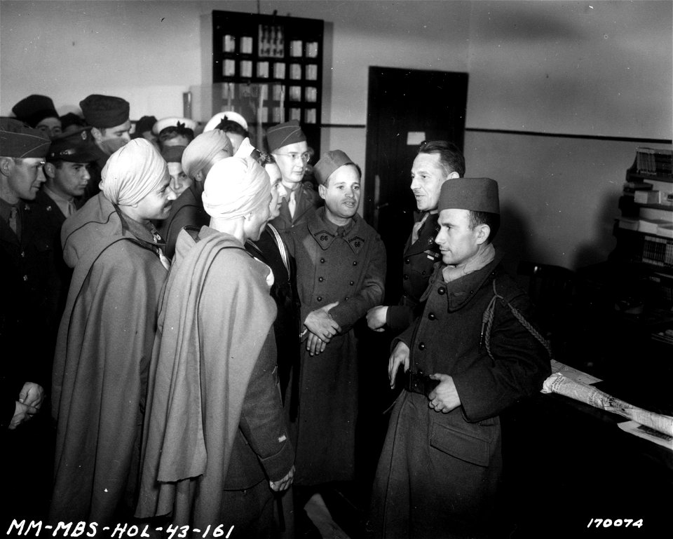 SC 170074 - Frederick O. Bird, director of the allied club in N. Africa is speaking to several Arabic Spahi troops (cavalry), who were inquiring concerning their friends. 20 February, 1943.
