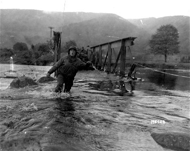 SC 195728 - When his reconnaissance car bogged down while crossing the Moselle River near Vecoux, France, Pvt. Otto Bruske, member of a tank destroyer battalion, Seventh Army, took to wading for assistance. 2 October, 1944.