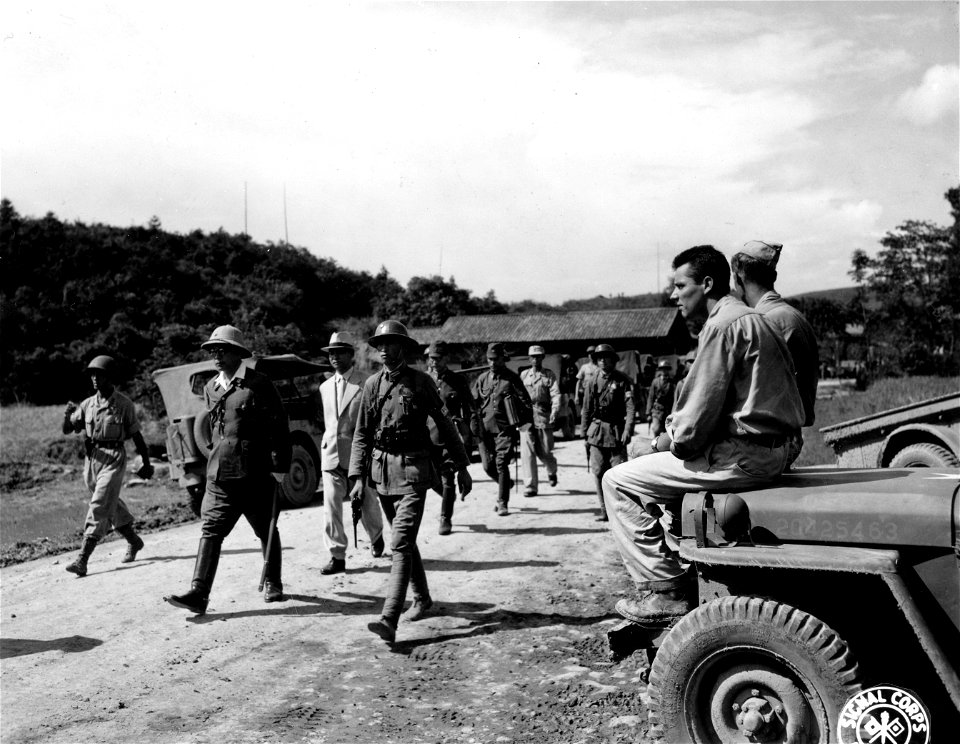 SC 221716 - Sitting on a jeep hood are two GIs watching as the Japanese Army emissaries arrive at Chinese Army HQs. at Chihkiang, China...