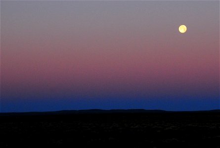 Strawberry moon setting over sage steppe at Seeskadee National Widlife Refuge Wyoming photo