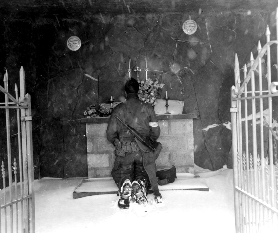 SC 199091 - Cpl. Charles S. McNulty, 2075 Beaver Ave., Cedar Rapids, Iowa, stops for a moment of prayer before joining his division near Houmont, Belgium. 8 January, 1945.