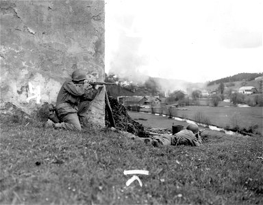 SC 270884 - Soldiers of 11th Armored Division, 3rd U.S. Army, fire on enemies across border in blazing town of Kepple, Austria, before end of war in Europe. 30 April, 1945. photo
