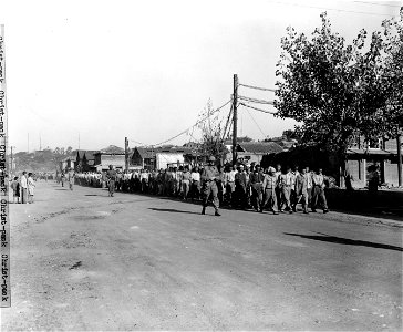 SC 349028 - U.S. Marines and soldiers march NK POWs through the streets of Inchon to a POW camp. 15 September, 1950. photo