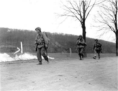 SC 270633 - Two riflemen and a bazookaman pass smoke screen on a road to Zweibrucken. 20 March, 1945. photo