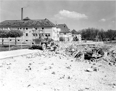 SC 336825 - A jeep carefully negotiates what is left of the bombed (12th T.A.C.) Hindenburg Bridge in town of Schwabisch Hall.