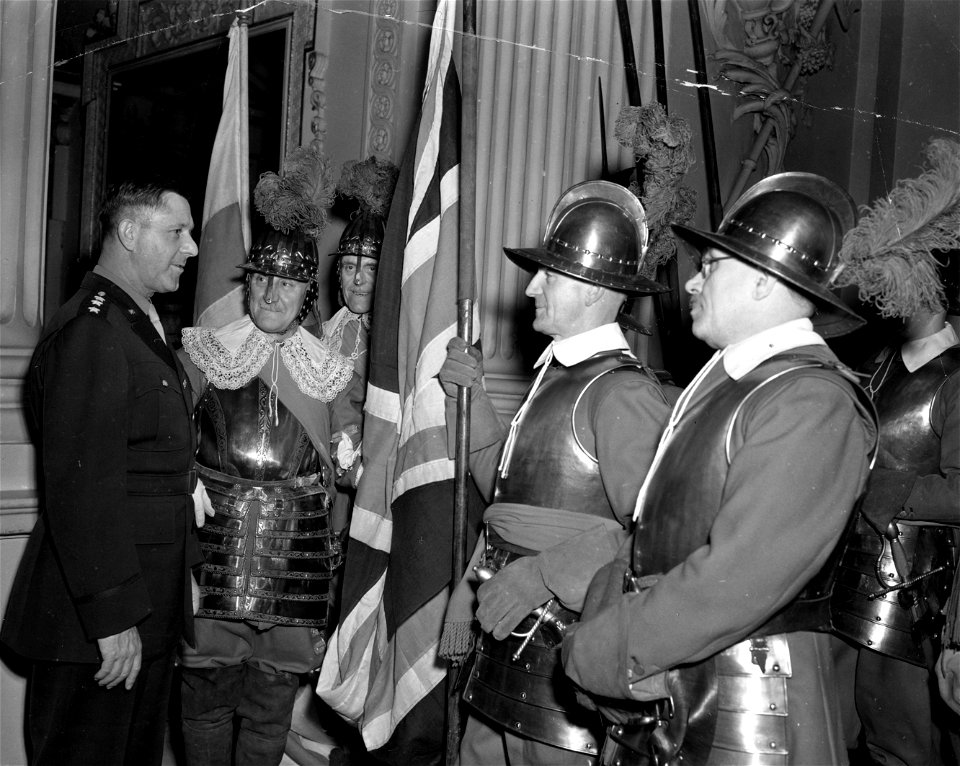 SC 329900 - Lt. Gen. Jacob L. Devers, left, chats with colorfully costumed pikemen who exchanged a flag of the city of London with one from Chicago during a ceremony held recently in London in the Lord Mayor's mansion. 10 December, 1943.