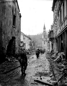 SC 335571 - In their advance to oust Nazis from the Prun river valley, infantrymen of the U.S. Third Army, 4th Infantry Div., move through the German city of Prum.