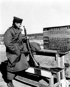 SC 221772 - Checking the scoreboard-Observing some of the scores that made him tops European Theater Army competitors in the model 1903 rifle firing is Capt. Charles Mason, 140 East 40th St. New York City. photo