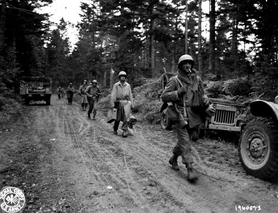 SC 196057-S - U.S. Infantrymen who were cut off by the Germans for six days in the Belmont sector, France, file down the road after being relieved. 31 October, 1944.