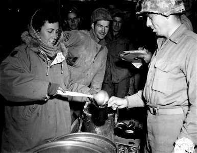 SC 329751 - Harriet L. Bonsen of the American Red Cross from Church Hill, New Canaan, pours cream in the coffee for a member of Fifth Army. 11 December, 1944. photo