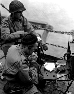 SC 171521 - Signal Corps radio crew on transport maintaining contact with first wave as it lands on Attu, Aleutians. 11 May, 1943. photo