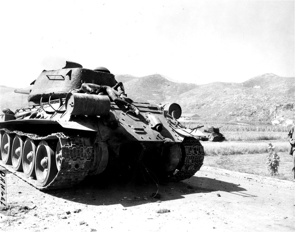 SC 349025 - Burned crewman of a NK T-34 tank which was knocked out, lies on top of the tank. 17 September, 1950.