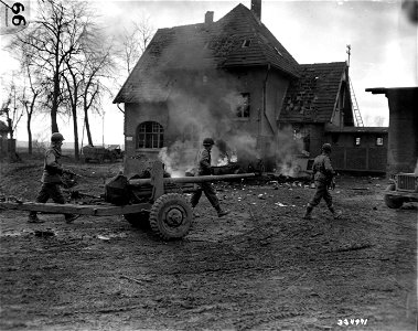 SC 334971 - Infantrymen of the Ninth U.S. Army move past a burning American jeep and trailer at Korrenzig, Germany. 24 February, 1945. photo