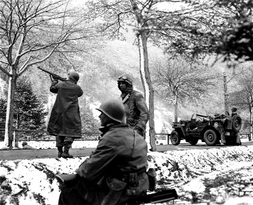 SC 337387 - (409th Task Force photo series) Here, while one man peppers away with his M1, machine gun sprays the mountain side with lead. 1 May, 1945. photo