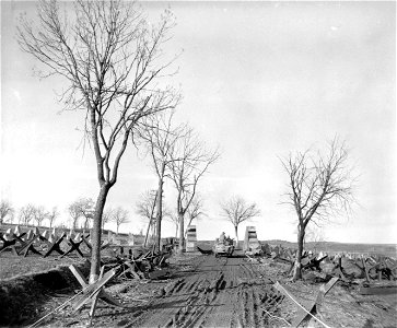 SC 336781 - A vehicle of the 11th Armored Division, U.S. Third Army, passes the roadblock, tank traps, and dragon's teeth of the Siegfried Line, near Nar-Uttfeld, Germany. 21 February, 1945. photo