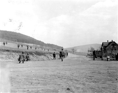 SC 270882 - Troops of an armored infantry unit move over hill and along road toward the town of Kronach, Germany, in Third U.S. Army sector. 12 April, 1945. photo