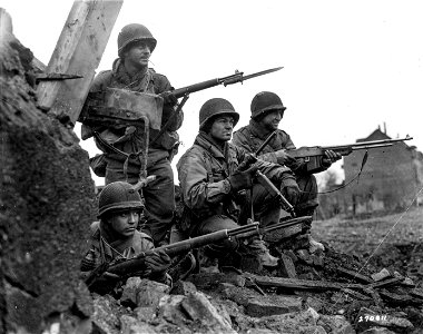SC 270811 - Infantrymen of the 8th Division, U.S. First Army, await orders to advance and clean out a building in Duren, Germany, occupied by about 30 or 40 Germans. 24 February, 1945. photo