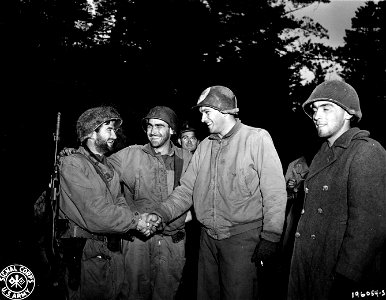 SC 196054-S - Bearded Lt. Martin J. Higgins, 29 Garrison Ave., Jersey City, N.J., left, receives a warm handshake from Lt. Charles O. Barry, 120 West St., Williamstown, P.A., when he rejoins his unit in the Belmont sector after being cut off... photo