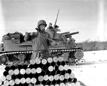 SC 364282 - Pvt. Herbert Reynolds, Dayton, Ohio, cleans his carbine using empty shells as a table during a lull in the fighting near Bastogne. 2 January, 1945. photo