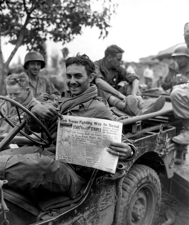SC 348872 - Sgt. Charles J. Burns, Galivants Ferry, S.C., Med Co., 5th RCT, reads of his outfit's achievements after participating in the fight for Weagwan. 19 September, 1950.