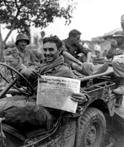 SC 348872 - Sgt. Charles J. Burns, Galivants Ferry, S.C., Med Co., 5th RCT, reads of his outfit's achievements after participating in the fight for Weagwan. 19 September, 1950.