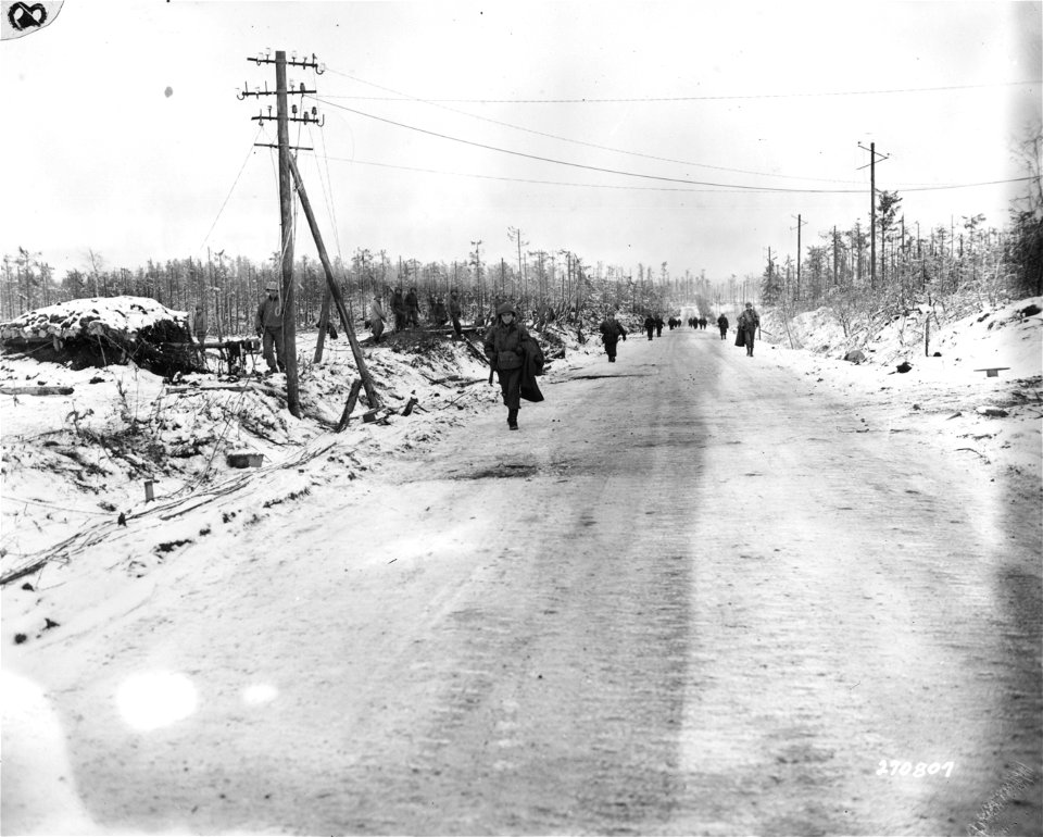SC 270807 - American reinforcements for the 121st Regt., who have just joined the 8th Division, U.S. Ninth Army, march up the road between Hurtgen and Germeter, Germany. 6 January, 1945.