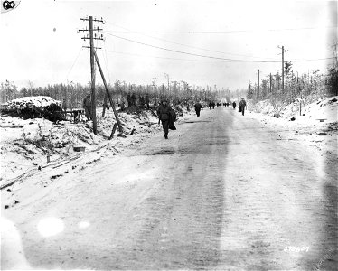 SC 270807 - American reinforcements for the 121st Regt., who have just joined the 8th Division, U.S. Ninth Army, march up the road between Hurtgen and Germeter, Germany. 6 January, 1945. photo