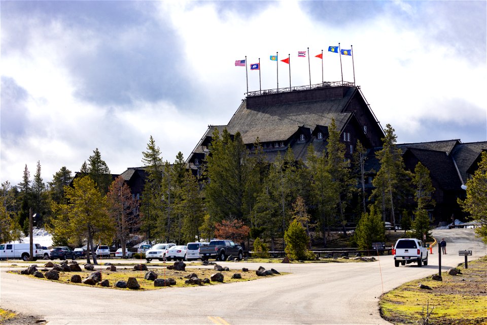 Yellowstone National Park Lodges 150 Years of Inspiration Event: Tribal, State, and US flags fly atop the Old Faithful Inn