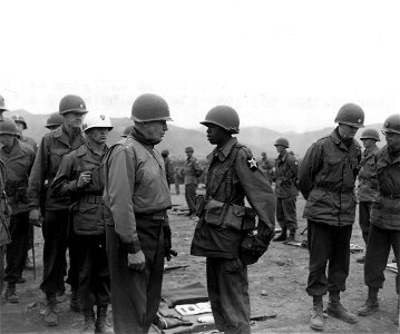 SC 364030 - Lt. Gen. Edward M. Almond (left) CG X Corps, stops to talk to Pfc. James H. Gatewood, Huntington, W.Va., (right) 2nd Bn., 9th Inf. Regt., 2nd Inf. Div... photo