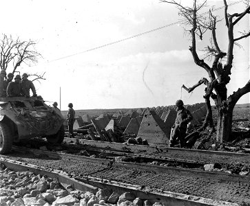 SC 336780 - Armored car of the 10th Armored Division, 3rd U.S. Army, drives through a hole blasted in dragon's teeth anti-tank defenses near Portz on drive to Saarburg, Germany. 21 February, 1945. photo