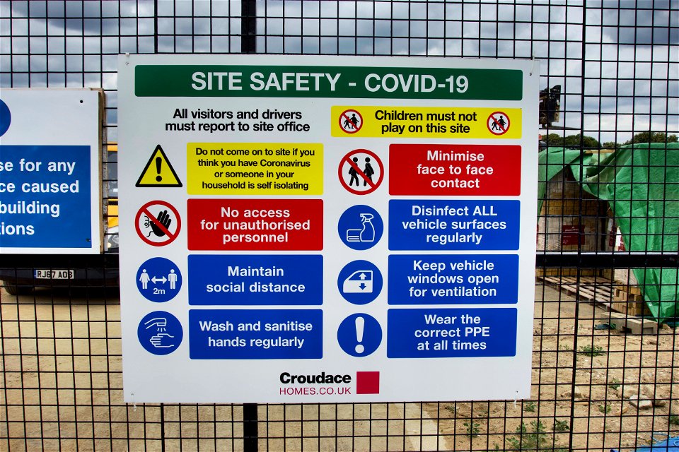 Sign of the times. COVID Corona Building site.