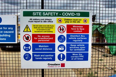 Sign of the times. COVID Corona Building site.