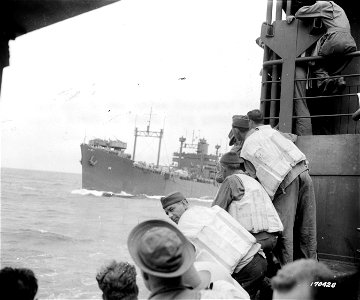 SC 170428 - Troops aboard transport watch one of the other ships in the convoy pull ahead of their ship. 30 June, 1942. photo