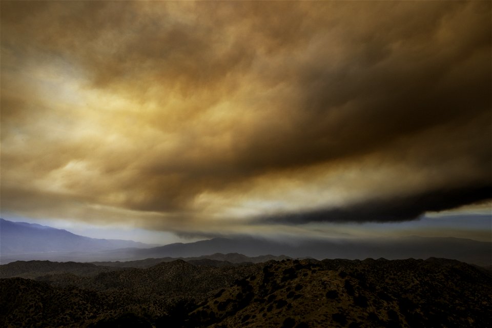 Smoke from the Apple Fire over desert hills photo