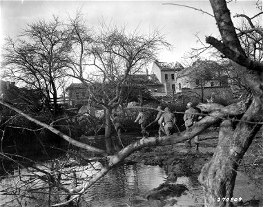 SC 270809 - Members of the 13th Infantry Regiment, 8th Div., wire patrol, move through wreckage of town near Ruhr River, just across from German-held town of Duren. 16 February, 1945.