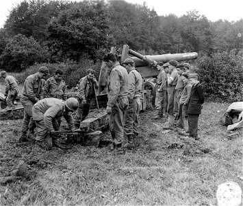 SC 195758 - Serious young Frenchmen watch U.S. field artillery men jack an 8 inch howitzer into position on a sector near Rambervillers, France.