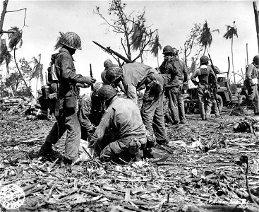 SC 270873 - Men of 7th Div. sample free cigarettes, brought to the front lines for distribution by the Red Cross.