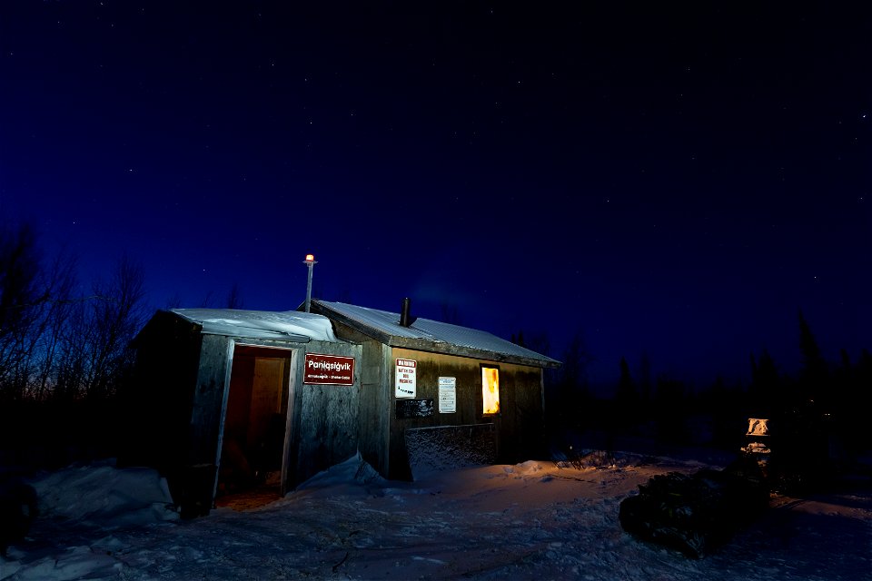 A snowmachine and sled outside the Paniqsigvik shelter cabin.