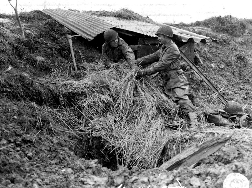 SC 195732 - This makeshift shelter is home to T/Sgt. Joe Chitwood, of Ironton, Mo., and Pfc. Francis Tuberville of Marton, S.C., as they improvise protection from the mud and rain. Near Nancy, France. 13 October, 1944.